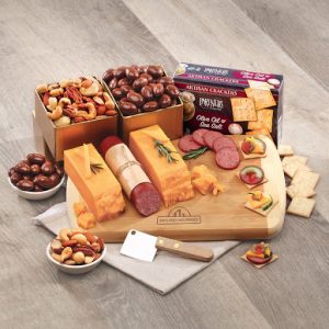 Cheese board displaying cheese, meat, nuts, and chocolate candy.